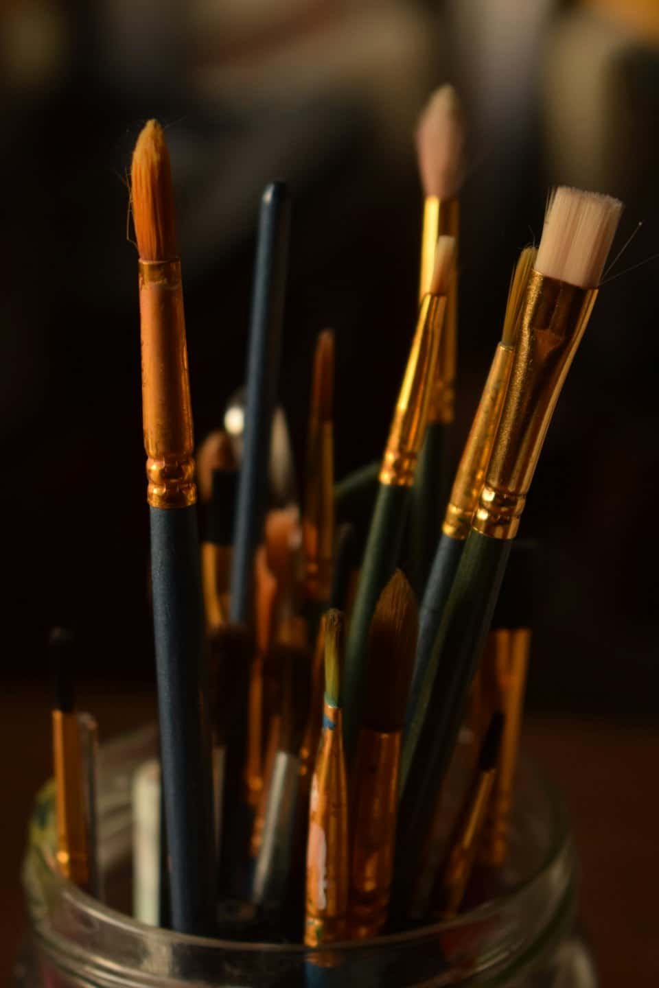 Pennelli da artista assortiti in piedi in un barattolo di vetro.
