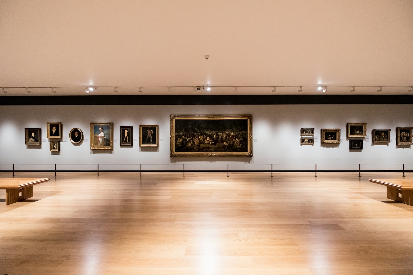 Quadri appesi in fila su una parete di galleria moderna.