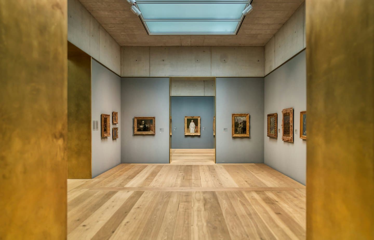 Galleria d'arte moderna con dipinti a olio su pareti grigie.
