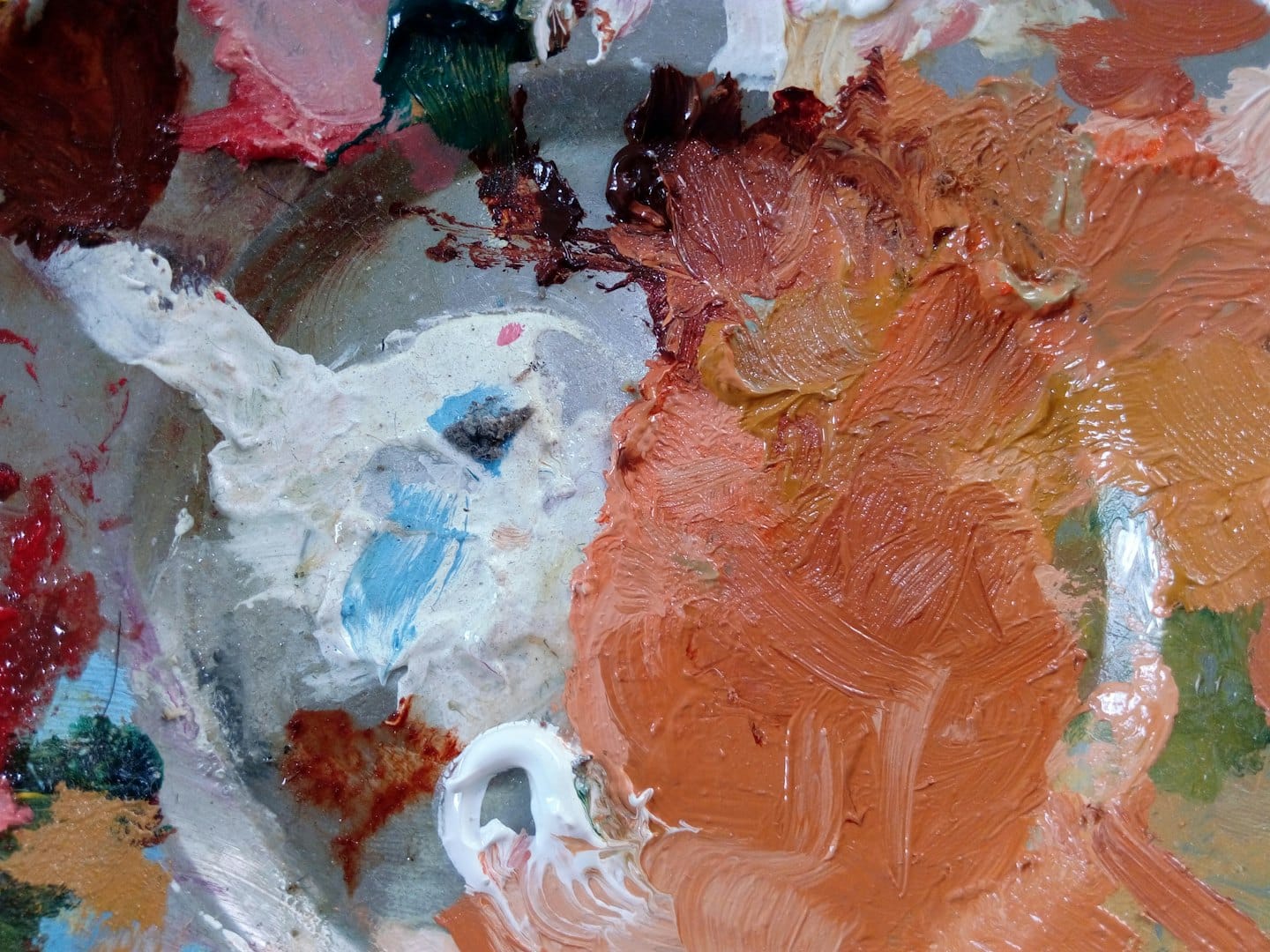 Tavolozza di un artista con spessi colori a olio nei toni del marrone e dell'arancione.